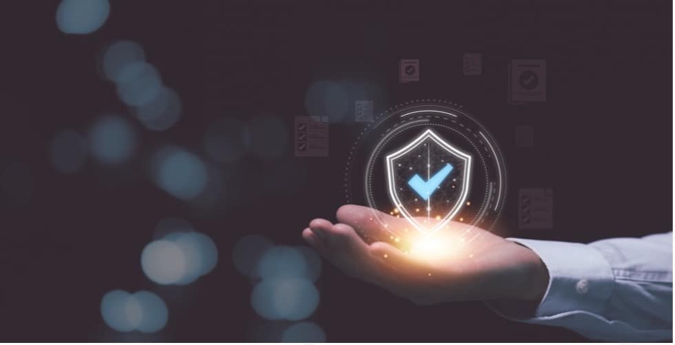 A hand holding a glowing shield